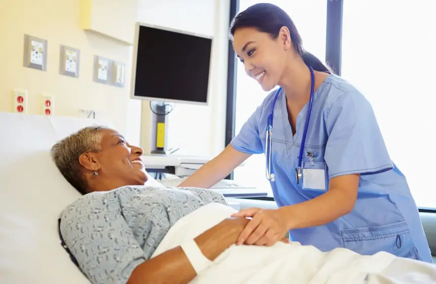 Nurse Talking To Senior Woman In Hospital Room